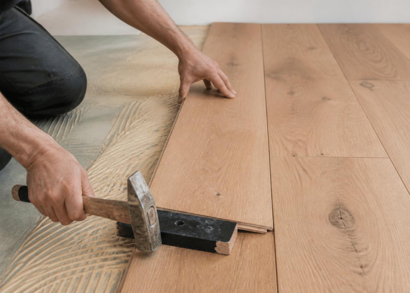 Profissional em obra a instalar um pavimento
